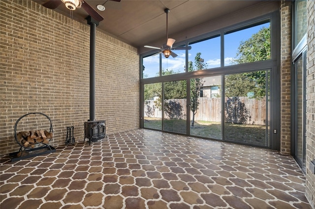 unfurnished sunroom featuring ceiling fan