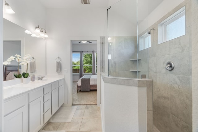 bathroom featuring tile patterned flooring, vanity, tiled shower, and ceiling fan