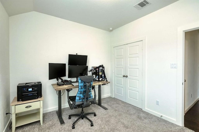 carpeted office featuring lofted ceiling