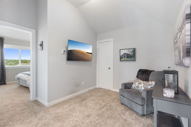 sitting room featuring carpet flooring, vaulted ceiling, and baseboards