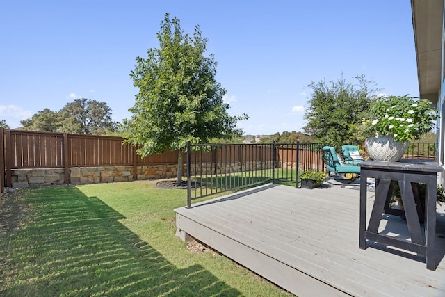 wooden terrace featuring a lawn