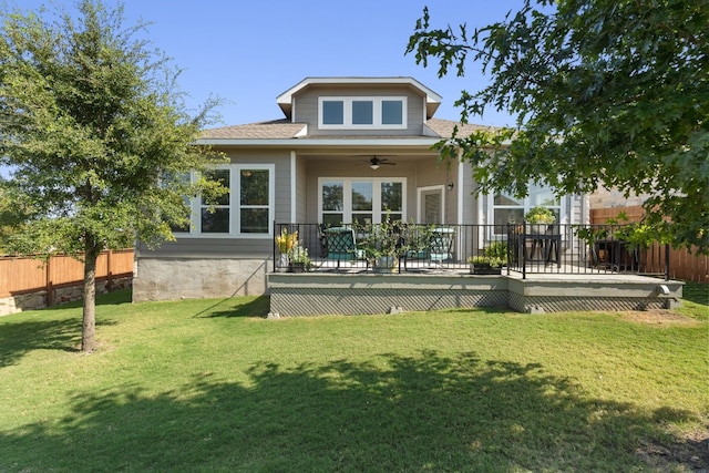 back of house with ceiling fan, fence, a lawn, and a wooden deck