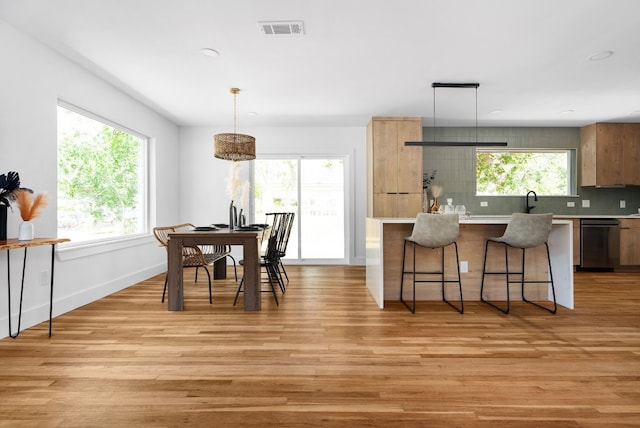 kitchen featuring pendant lighting, decorative backsplash, and light hardwood / wood-style floors