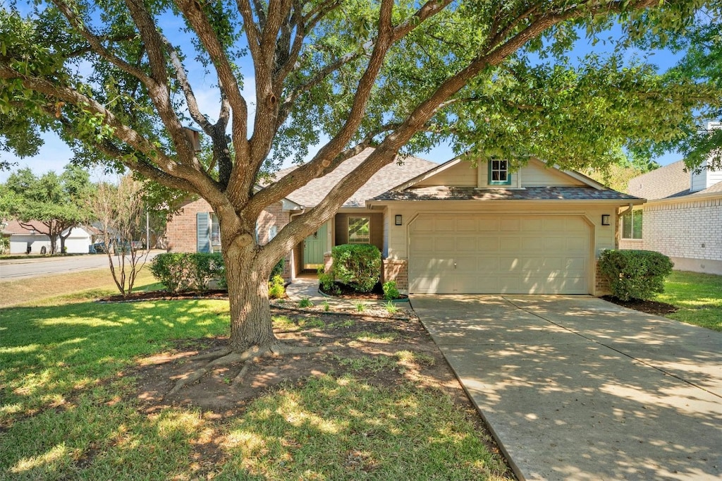 single story home featuring a garage, driveway, and a front lawn