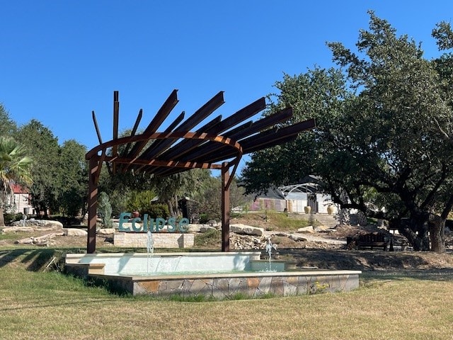 view of property's community featuring a pergola and a lawn