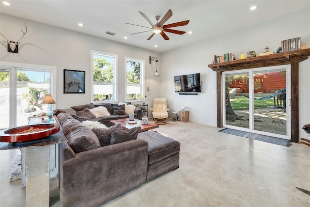 living room featuring ceiling fan and concrete floors