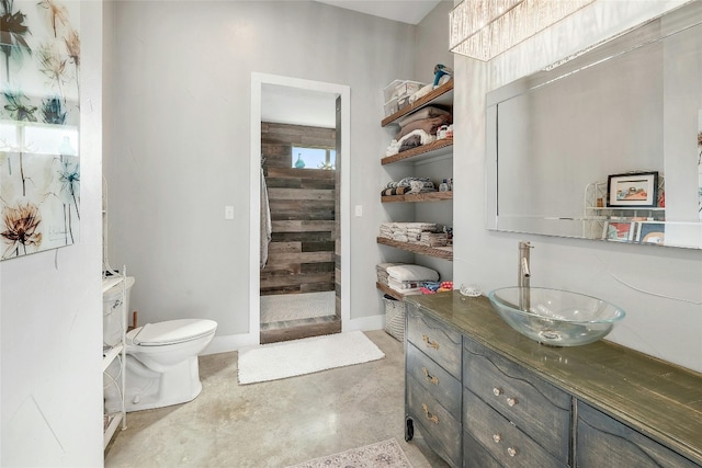 bathroom featuring vanity, toilet, and concrete floors