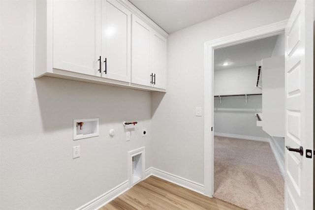 laundry room featuring cabinets, washer hookup, hookup for an electric dryer, hookup for a gas dryer, and light hardwood / wood-style floors