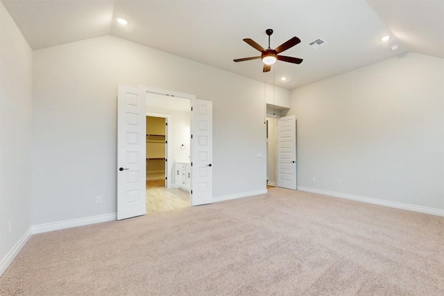 unfurnished bedroom featuring ceiling fan, light carpet, and vaulted ceiling