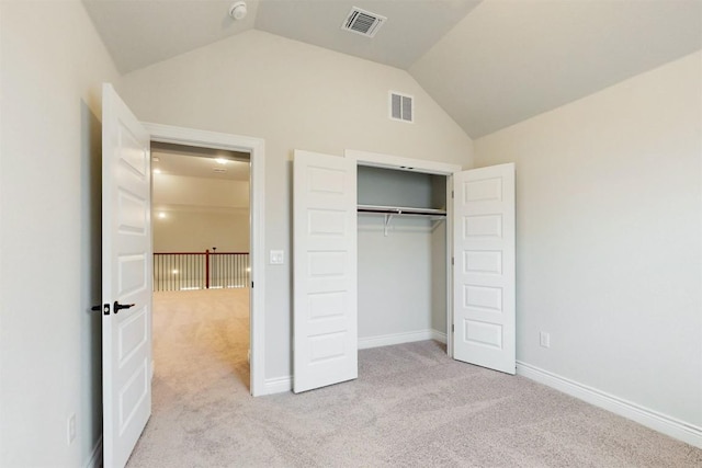 unfurnished bedroom with light colored carpet, high vaulted ceiling, and a closet