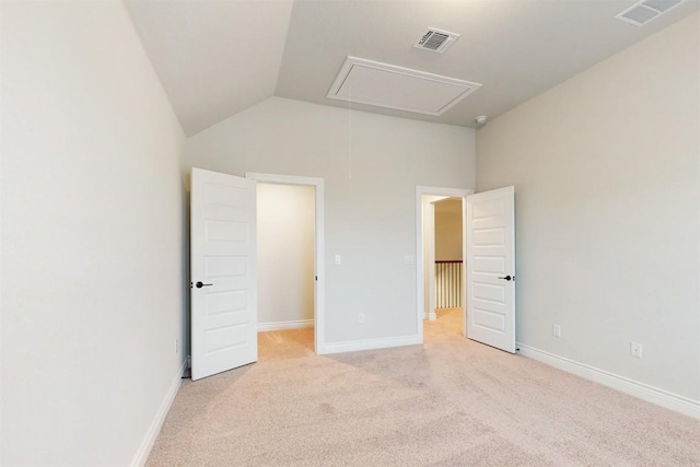 unfurnished bedroom with light colored carpet and vaulted ceiling