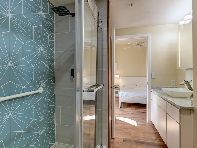 bathroom featuring ceiling fan, walk in shower, vanity, and hardwood / wood-style flooring