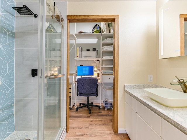 bathroom with walk in shower, vanity, and hardwood / wood-style flooring