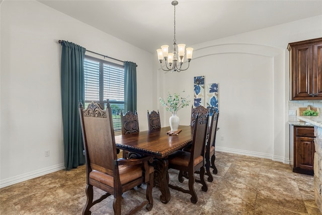 dining area featuring arched walkways, a notable chandelier, and baseboards