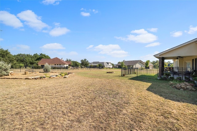 view of yard featuring ceiling fan and fence