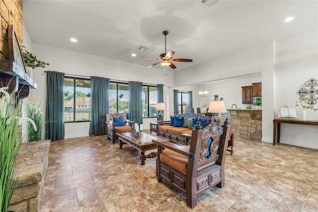 504 Pheasant Mdw, Liberty Hill, TX 78642 - living room with ceiling fan, recessed lighting, a chandelier, baseboards, and light stone finish floors