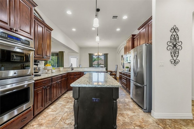 504 Pheasant Mdw, Liberty Hill, TX 78642 - kitchen featuring stainless steel appliances, a peninsula, a sink, a center island, and a chandelier