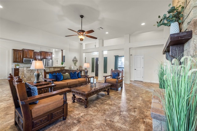 living room with ceiling fan, recessed lighting, a towering ceiling, visible vents, and baseboards