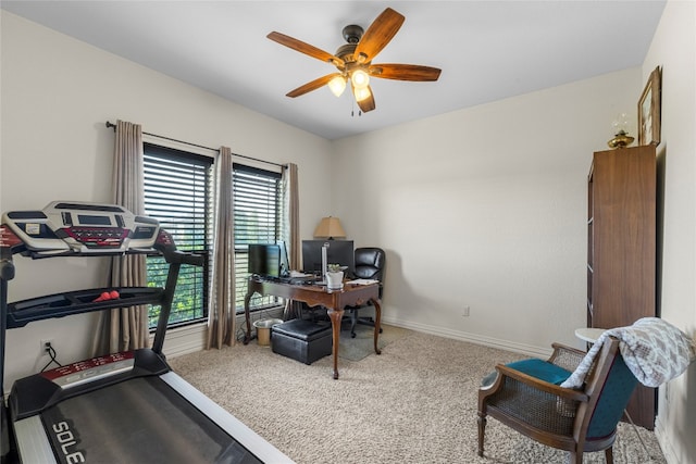 carpeted office space featuring ceiling fan