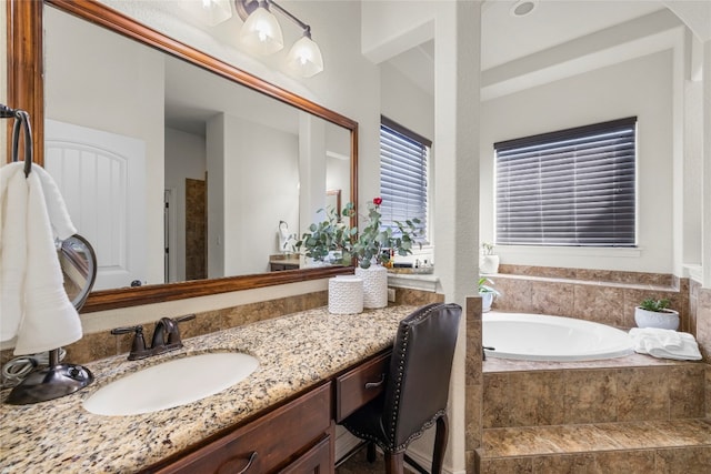 bathroom featuring vanity and a relaxing tiled tub