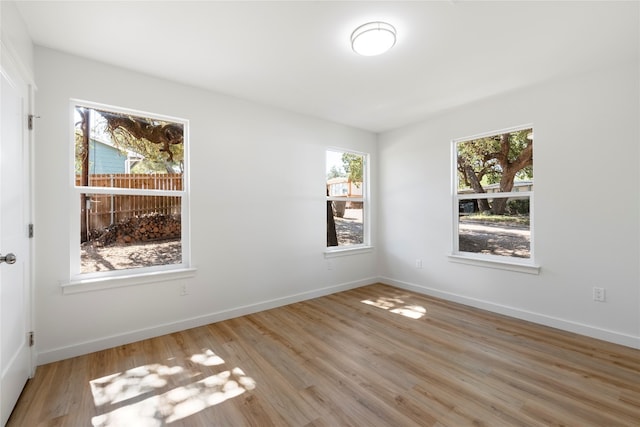 spare room featuring wood finished floors and baseboards