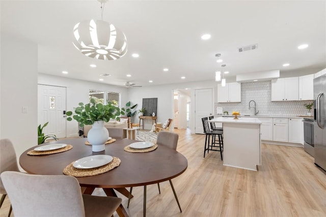 dining room featuring visible vents, recessed lighting, ceiling fan with notable chandelier, and light wood-style floors