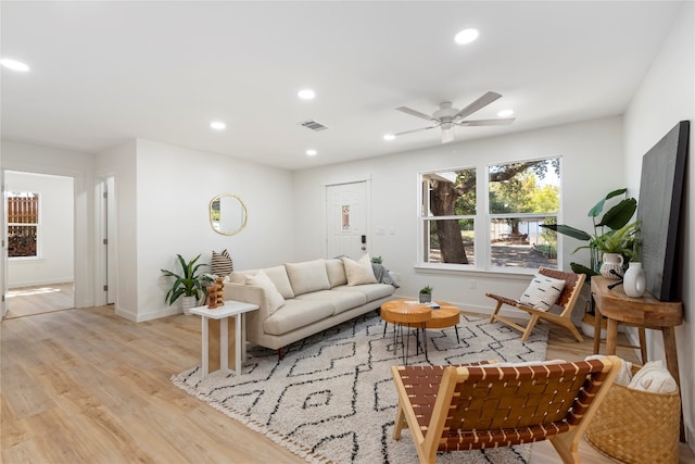 living room with ceiling fan and light hardwood / wood-style flooring