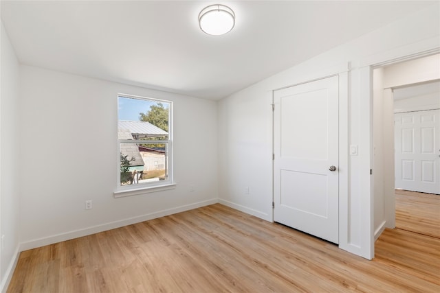 unfurnished bedroom with baseboards and light wood-type flooring