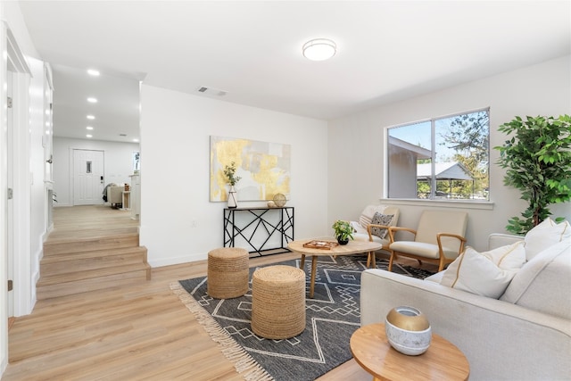 living area with recessed lighting, visible vents, baseboards, and light wood-style flooring