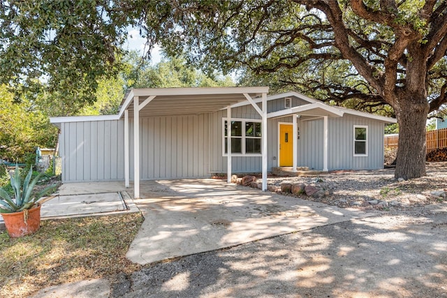 view of front facade featuring a carport, driveway, and fence