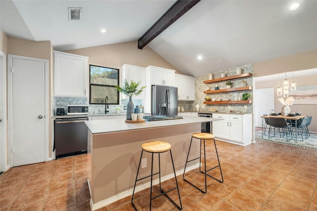 kitchen featuring a kitchen island, a kitchen breakfast bar, decorative backsplash, and stainless steel appliances