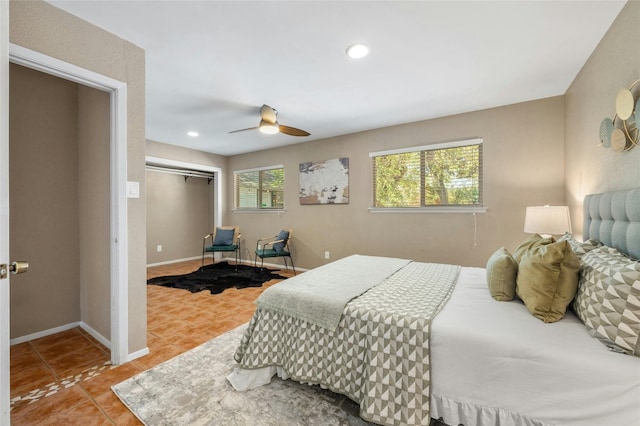 tiled bedroom featuring ceiling fan, a closet, and multiple windows