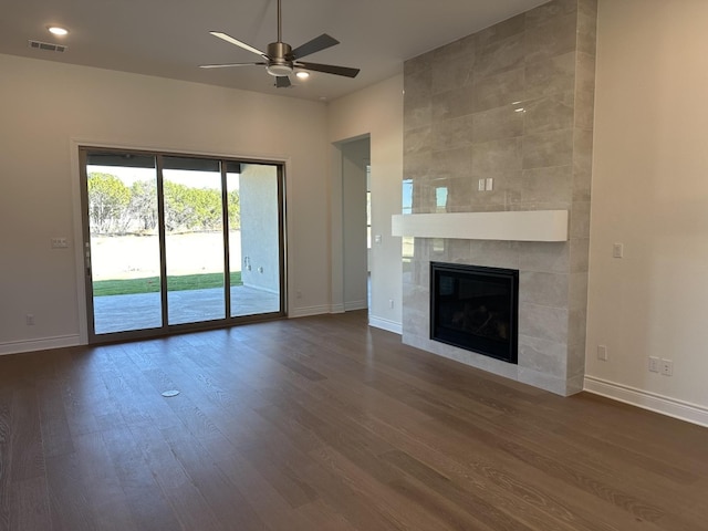 unfurnished living room with ceiling fan, wood-type flooring, and a tile fireplace