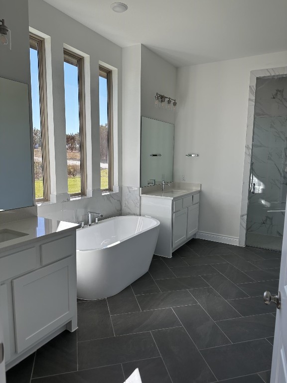 bathroom with tile patterned flooring, vanity, and a bath