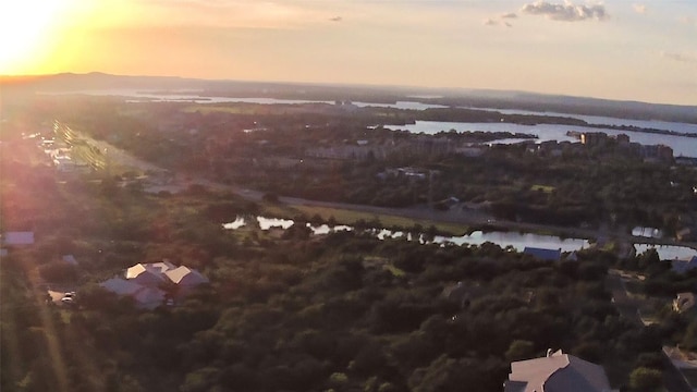 aerial view at dusk featuring a water view