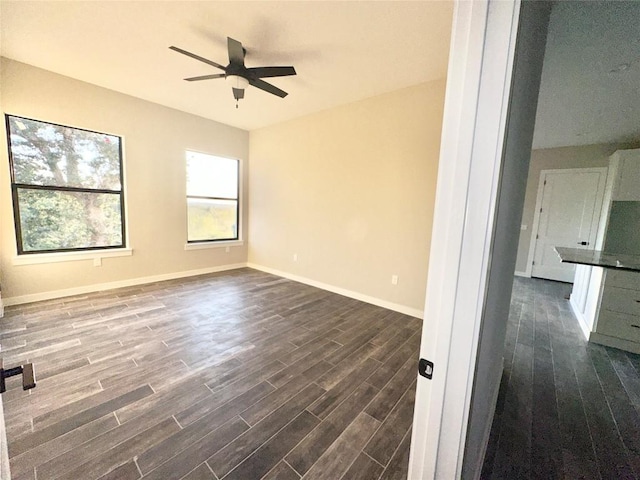 unfurnished room featuring ceiling fan and dark wood-type flooring