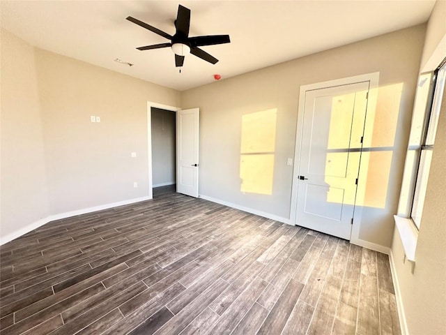 unfurnished bedroom featuring ceiling fan and dark hardwood / wood-style flooring