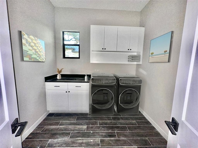 clothes washing area featuring cabinets and independent washer and dryer