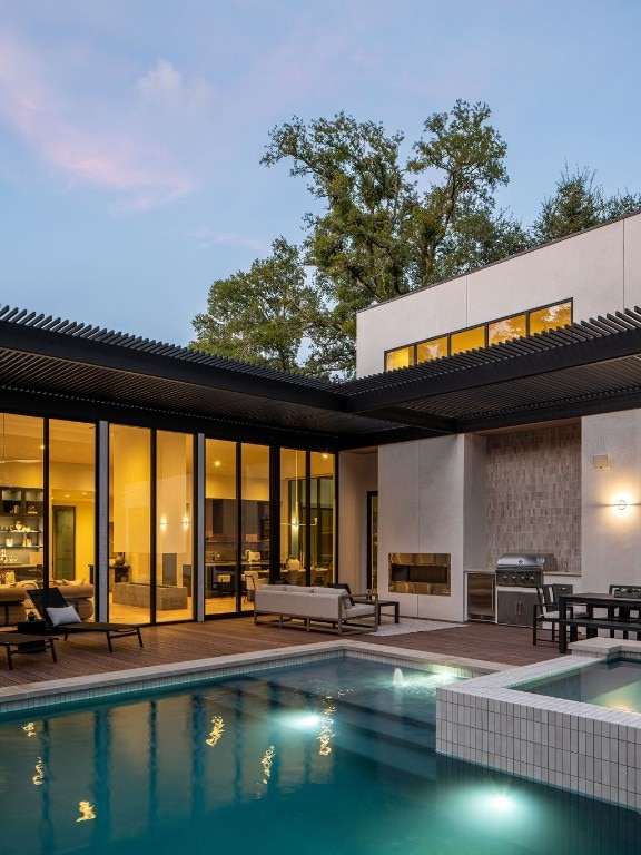 back house at dusk with a pool with hot tub and a patio area