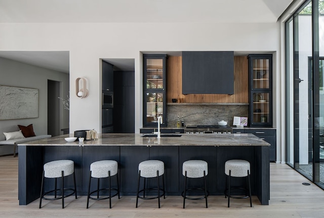 kitchen featuring backsplash, a kitchen bar, and light wood-type flooring