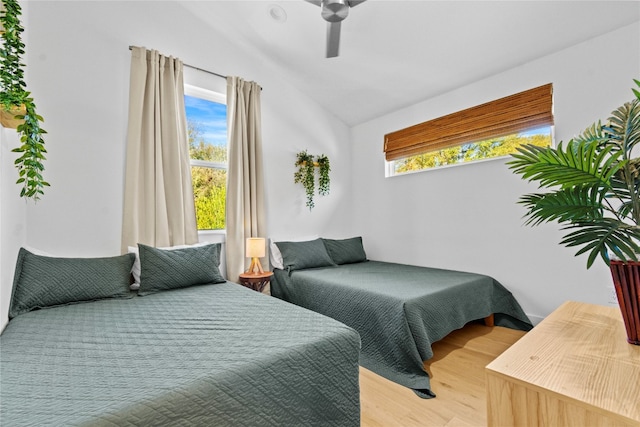 bedroom with ceiling fan, hardwood / wood-style flooring, lofted ceiling, and multiple windows