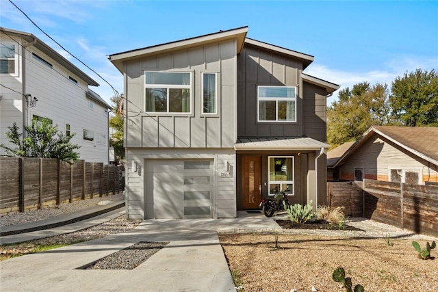 contemporary house featuring concrete driveway, board and batten siding, and fence