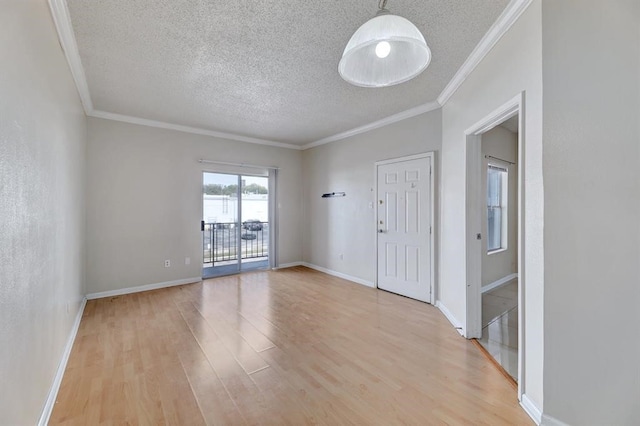 interior space featuring ornamental molding, light wood-type flooring, and a textured ceiling