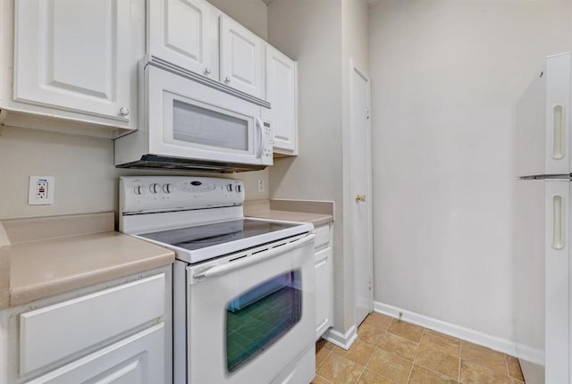 kitchen with white cabinets, light tile patterned flooring, and white appliances