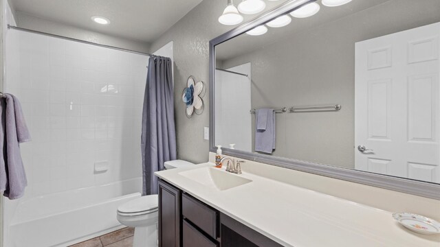 full bathroom with tile patterned flooring, vanity, shower / bath combo with shower curtain, and toilet