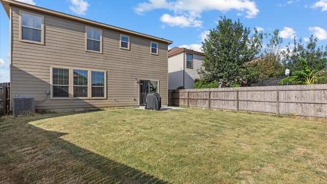 back of property with a lawn and central air condition unit