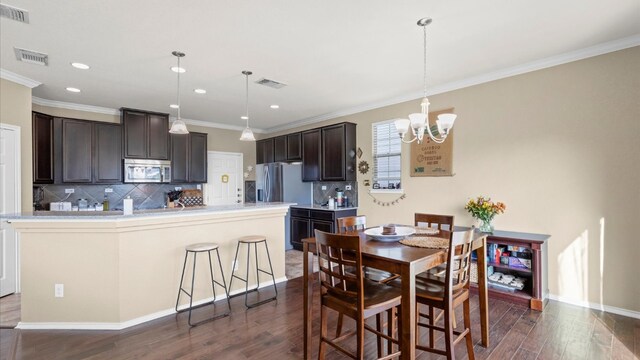 dining room with a notable chandelier, crown molding, and dark hardwood / wood-style flooring