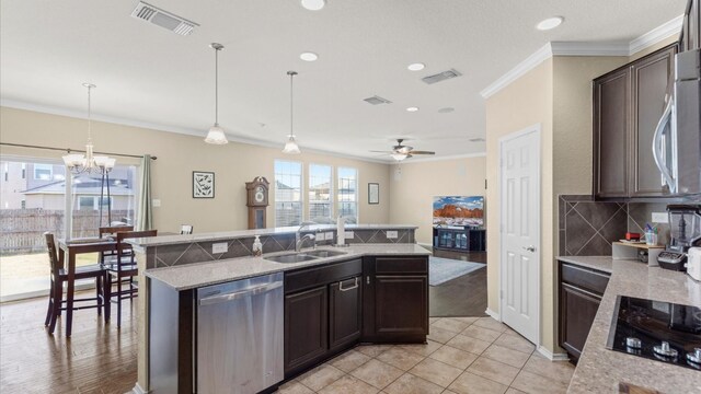 kitchen featuring crown molding, black electric cooktop, decorative light fixtures, dishwasher, and an island with sink