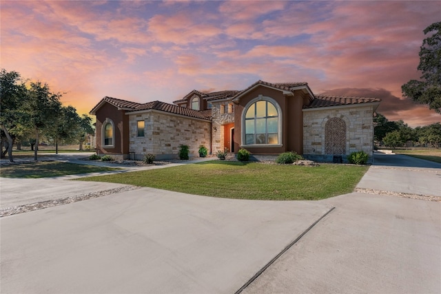 mediterranean / spanish home with a lawn