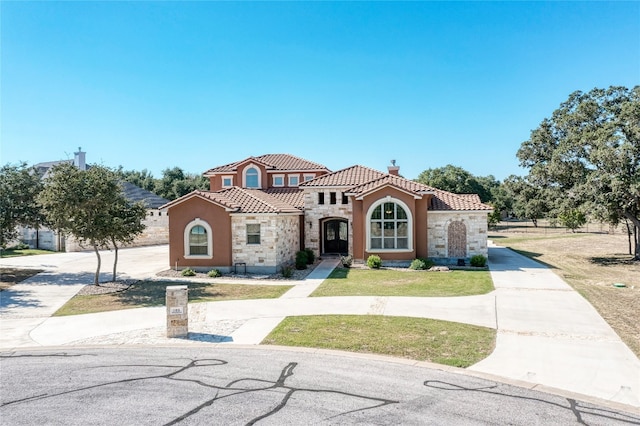 mediterranean / spanish-style home with a front lawn